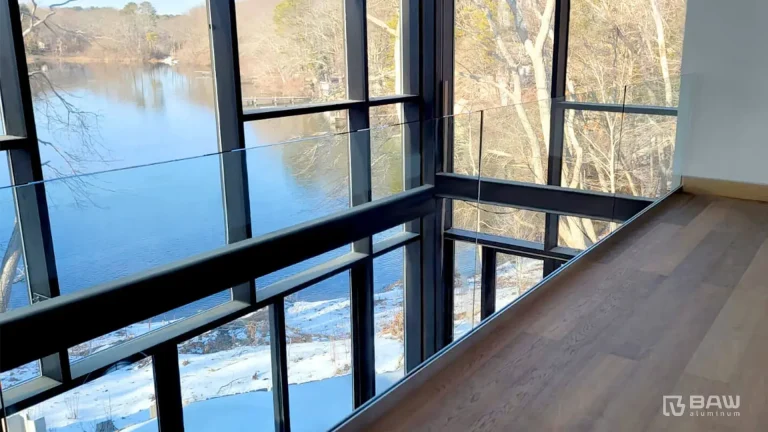 Glass railing and window wall system details on lakefront home